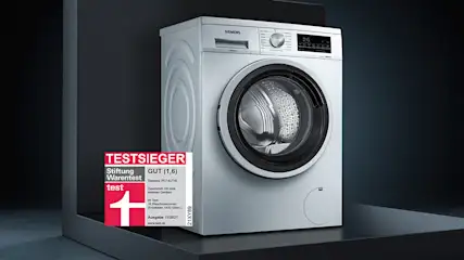 Eine Waschmaschine steht in einem leeren Raum