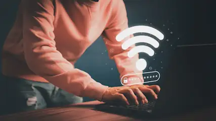 Ein Mann gibt auf dem Laptop ein WLAN-Passwort ein.