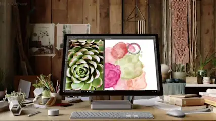 Ein Schreibtisch mit einem Monitor und einer Tastatur darauf steht vor einer Holzwand.