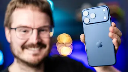 Michael präsentiert lächelnd die Rückseite des blauen iPhone 17 Pro Max.