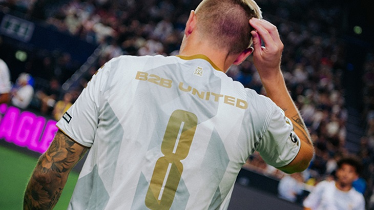 Ein Mann in einem weißen Trikot mit der Nummer 8 und der Aufschrift "B2B UNITED" steht vor einer Menschenmenge.