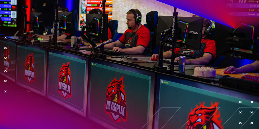 Eine Menschenmenge steht vor einer Anzeigetafel mit einer Punktetabelle, flankiert von Porträtbannern auf einem Event.