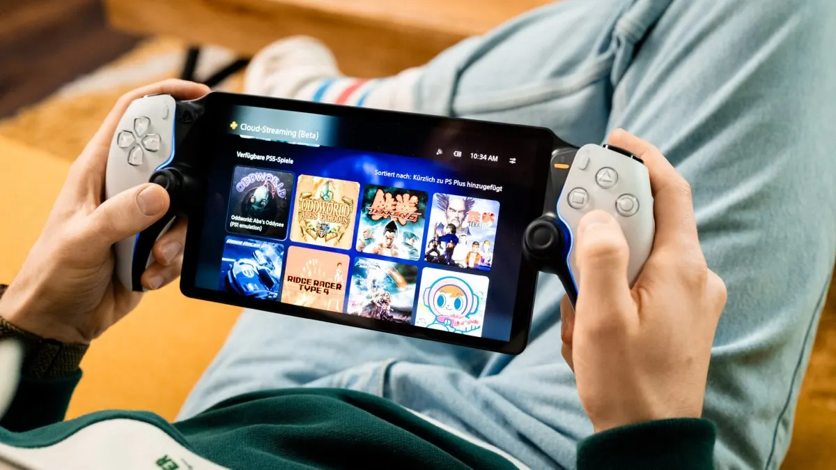 Niklas hält ein PlayStation Portal mit angeschlossenen weißen Controllern in den Händen. Auf dem Bildschirm sind Spielecover in der Games-Bibliothek (Beta) zu sehen.