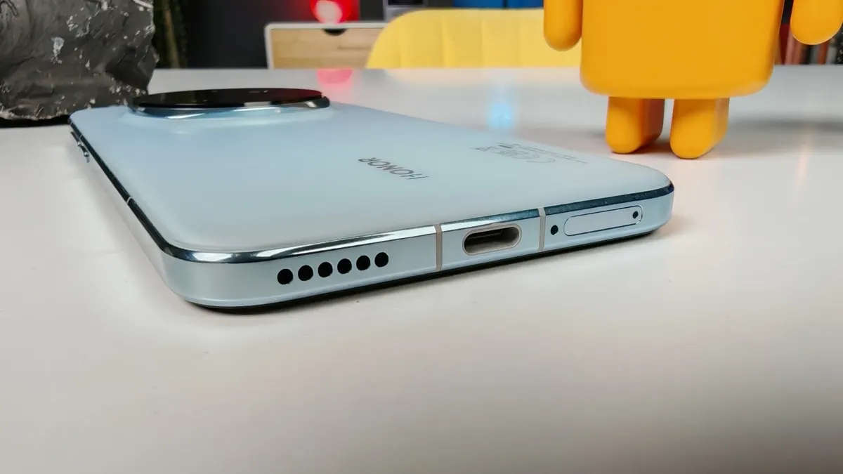 Das Honor Magic7 Pro liegt mit der Rückseite nach oben auf einem Tisch, zu sehen sind die Anschlüsse an der Unterseite.