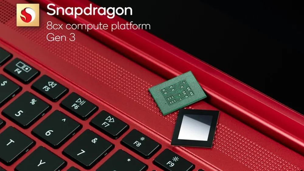 Roter Laptop mit schwarzer Tastatur, darauf ein grüner Chip und ein schwarzer Chip mit silbernem Rechteck. Oben links das Snapdragon-Logo.