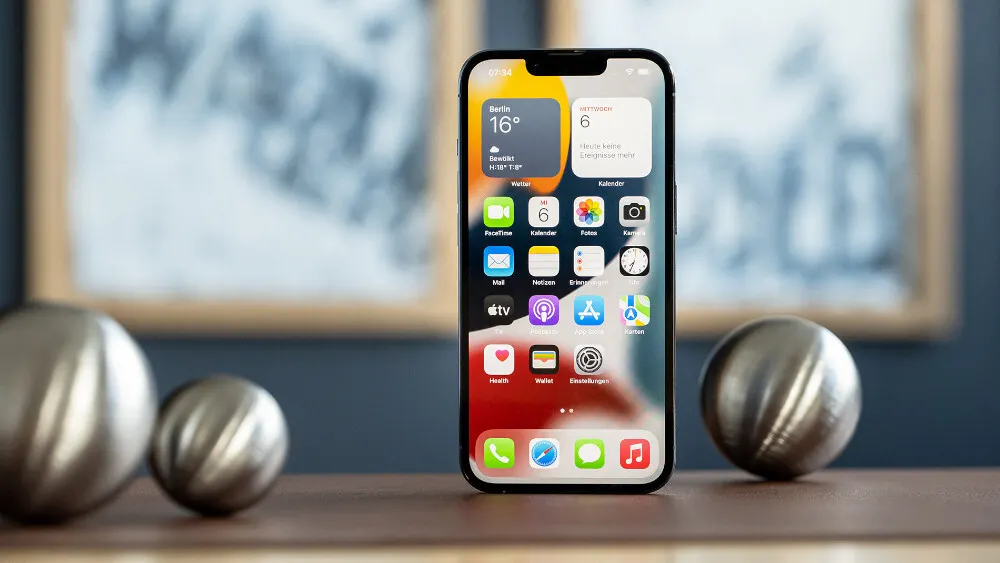 Ein iPhone 13 Pro steht auf einem Tisch.
