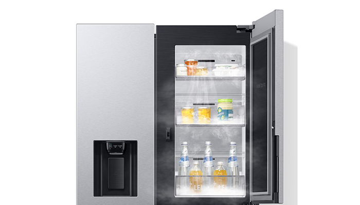 Silberner Kühlschrank, eine Tür geöffnet. Regale mit Flaschen und Behältern sichtbar. Wasserspender an der geschlossenen Tür.