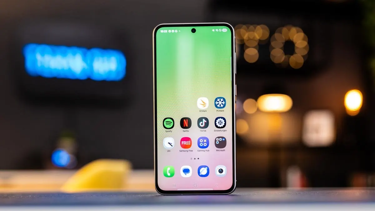 Das Smartphone Samsung Galaxy A36 steht mit eingeschaltetem Display auf einem Tisch.