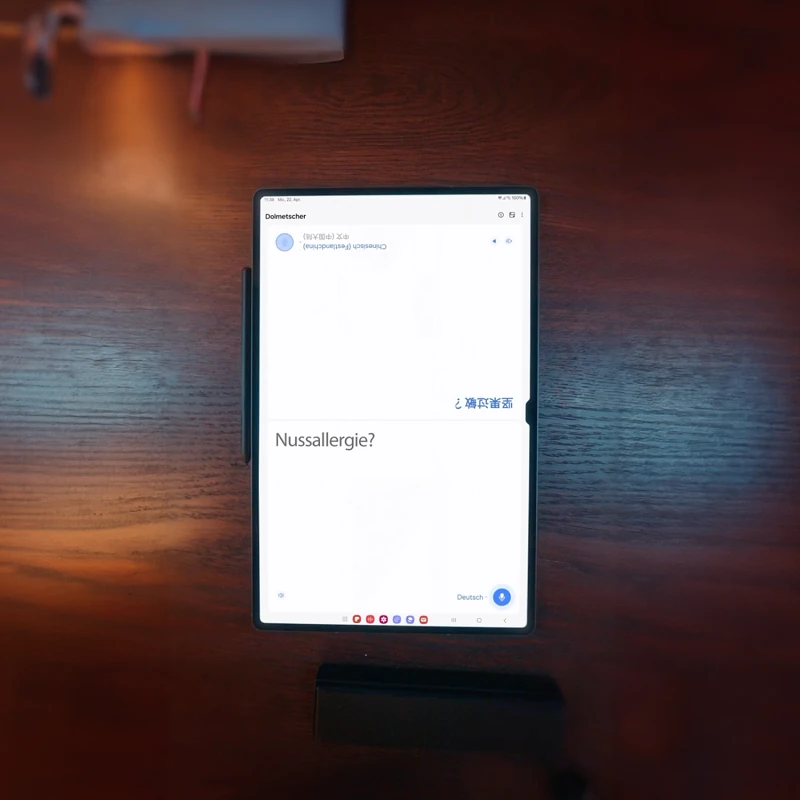 Ein Tablet zeigt die Frage "Nussallergie?" auf einem Holztisch. Ein Stift liegt links daneben.