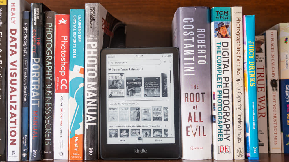 Ein Amazon E-Reader steht in einem Bücherregal.