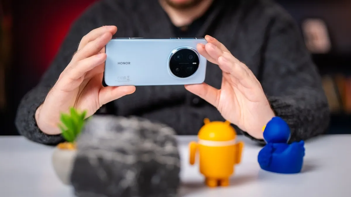 Andreas hält das Honor Magic7 Pro in beiden Händen und fotografiert einige kleine Figuren.
