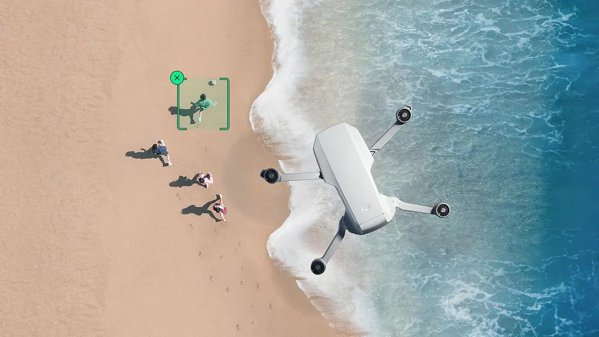 Die Mini-Drohne DJI Mini 4K fliegt über vier Personen, die am Strand langlaufen.