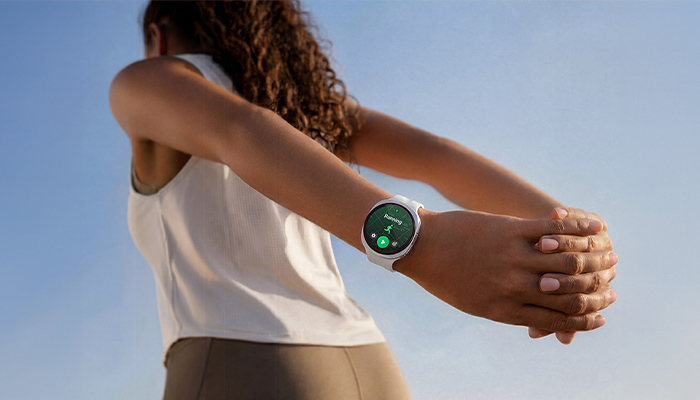 Galaxy Watch9 am Handgelenk während einer Dehnübung im Freien. Smarte Fitness- und Gesundheitsfunktionen für einen aktiven Alltag. 