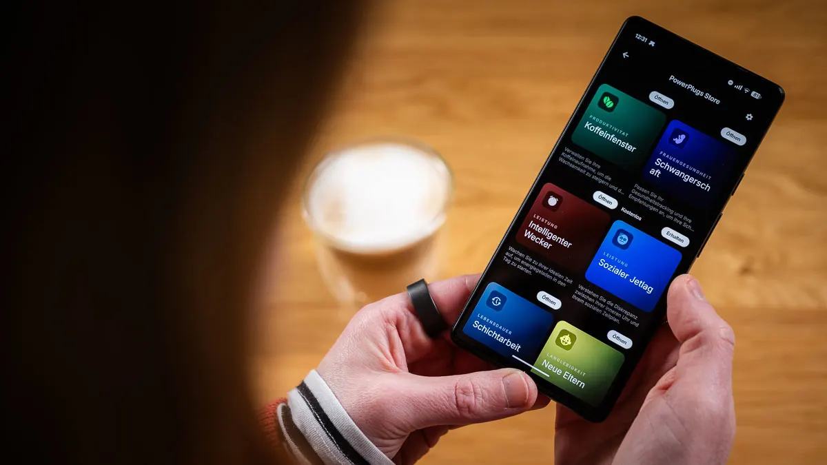 Franzi trägt den Ultrahuman Ring Air am linken Zeigefinger und schaut sich PowerPlugs in der Ultrahuman-App an.