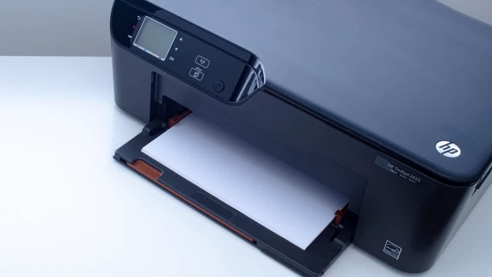 Ein HP-Drucker mit Papier befüllt.