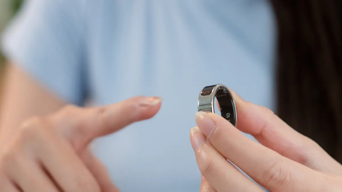 Eine Frau steckt einen Smart-Ring auf ihren rechten Zeigefinger. (Adobe Stock, Datei Nr.: #1780928748)