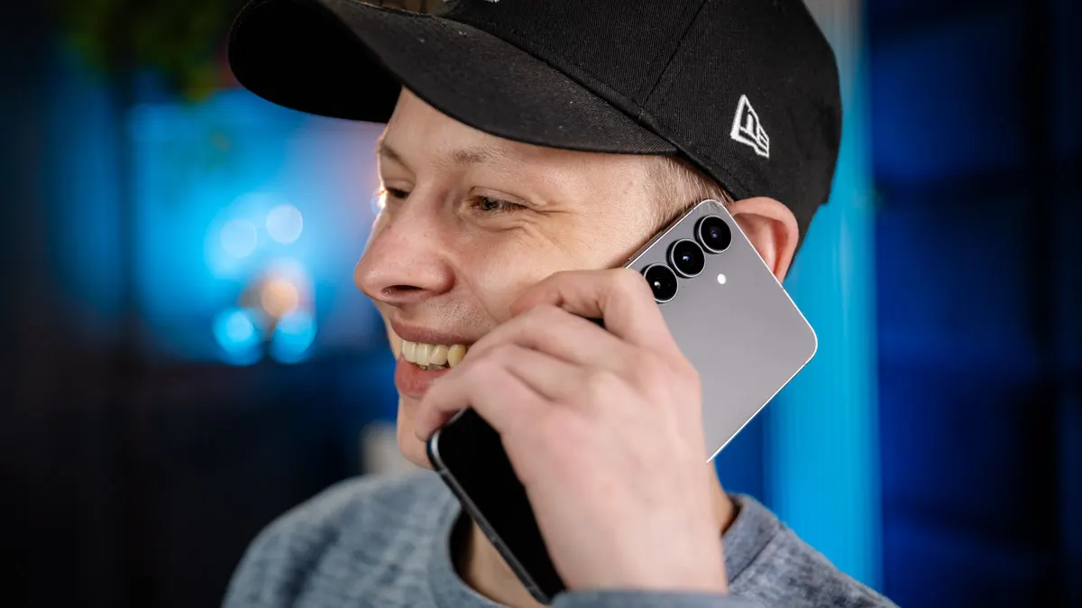 Alex hält sich das Smartphone Samsung Galaxy S25 FE ans Ohr.