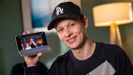 Alex hält das halb ausgeklappte Smartphone Google Pixel 10 Pro Fold in der Hand.