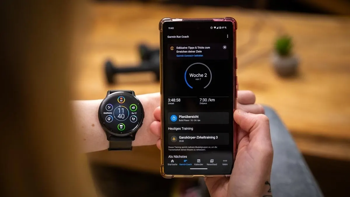 Franzi schaut sich auf dem Smartphone die Vorschläge des Garmin Run Coach in der Connect-App an und trägt die Garmin Venu 3.