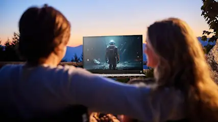 Ein Mann und eine Frau schauen auf dem PEAQ PTV 32GF-5025C-B unter freiem Himmel einen Film.