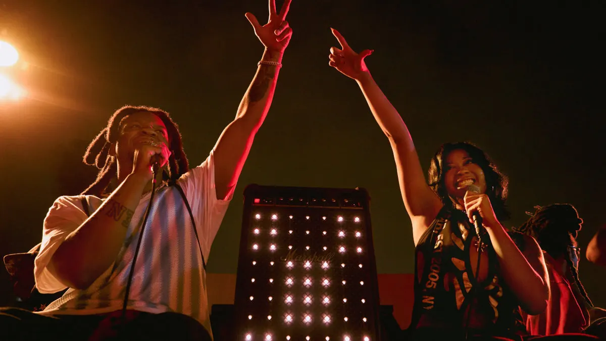 Der US-Rapper Denzel Curry und eine Sängerin stehen vor dem Party-Lautsprecher Marshall Bromley 750, dessen LEDs eingeschaltet sind.
