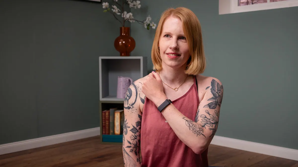 Franzi hält ihren linken Arm schräg vor dem Körper, am Handgelenk trägt sie das Fitbit Air.