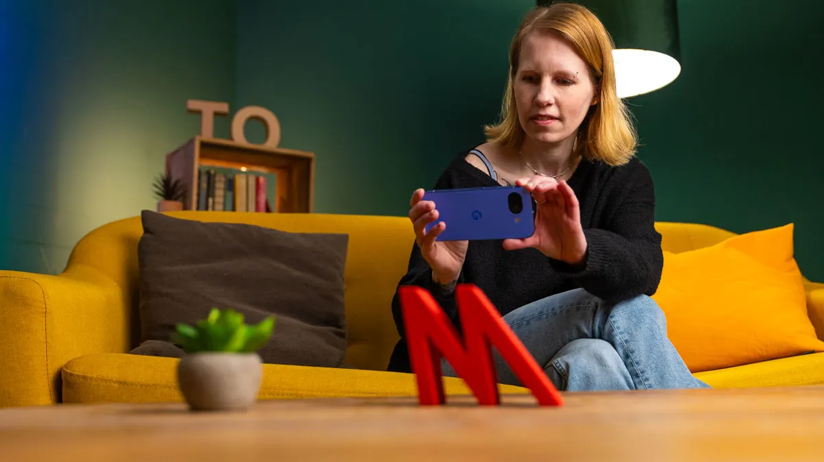 Franzi fotografiert einen roten „M“-Deko-Buchstaben mit dem Pixel 10a.