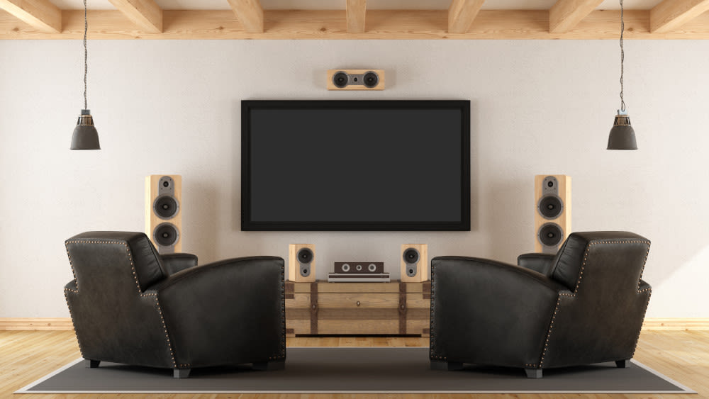Ein Lautsprecher-Surround-System im Wohnzimmer mit Sesseln und Fernseher