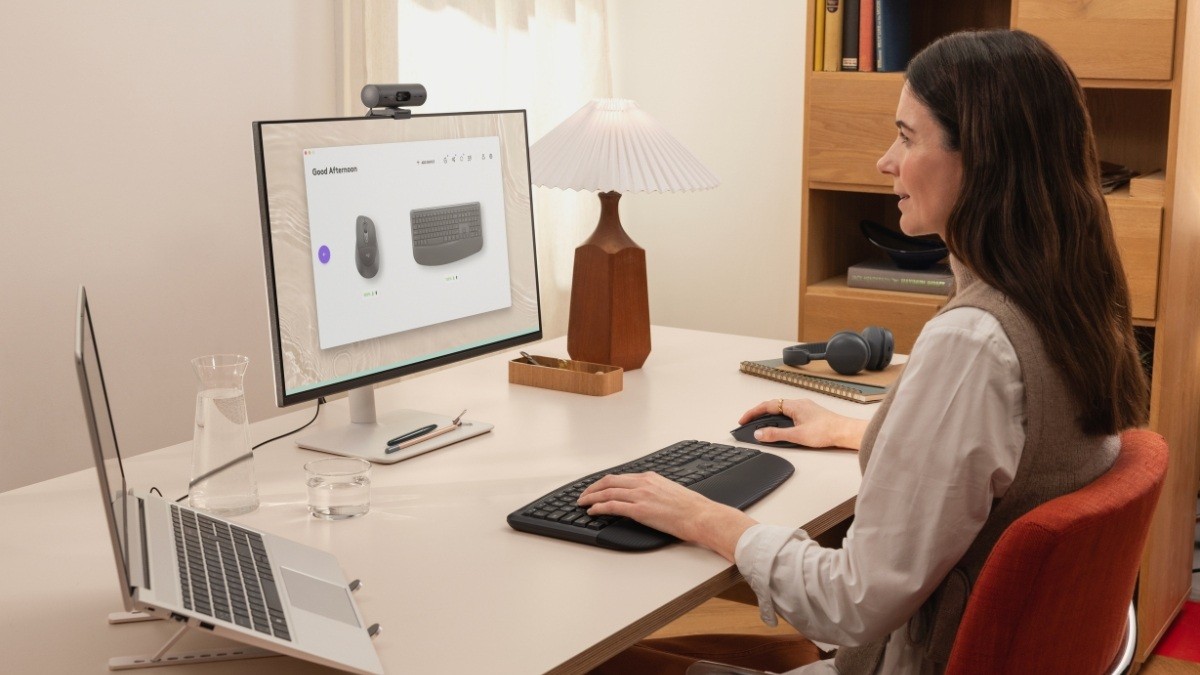 Eine Frau arbeitet an einem Schreibtisch mit Maus und Tastatur aus der Signature-Comfort-Plus-Reihe von Logitech.