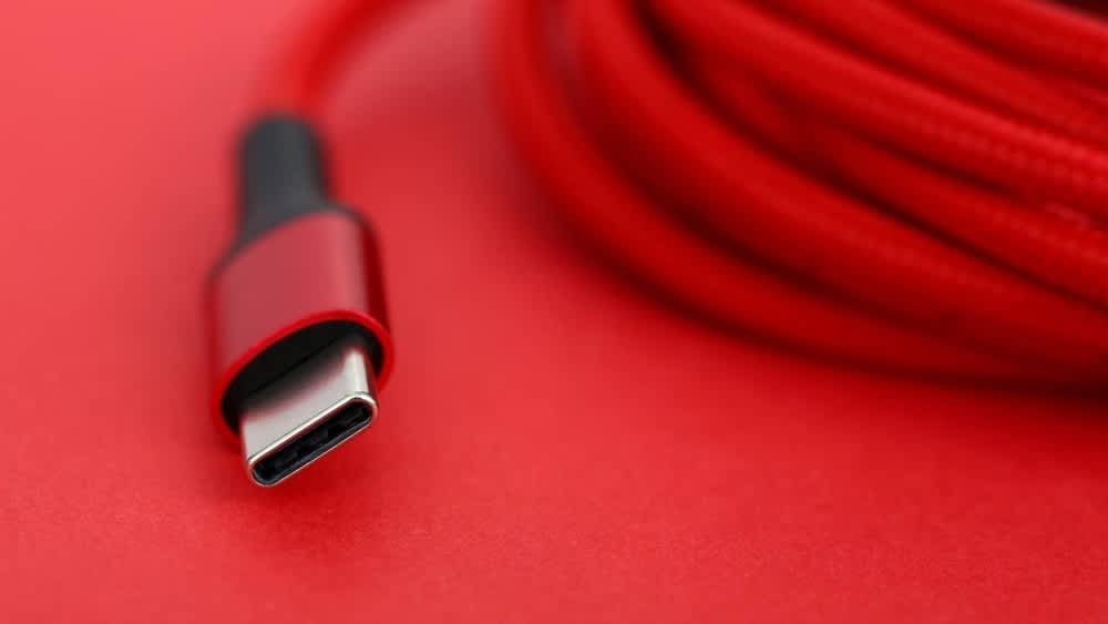 Ein rotes USB-C-Kabel liegt auf einer roten Oberfläche.