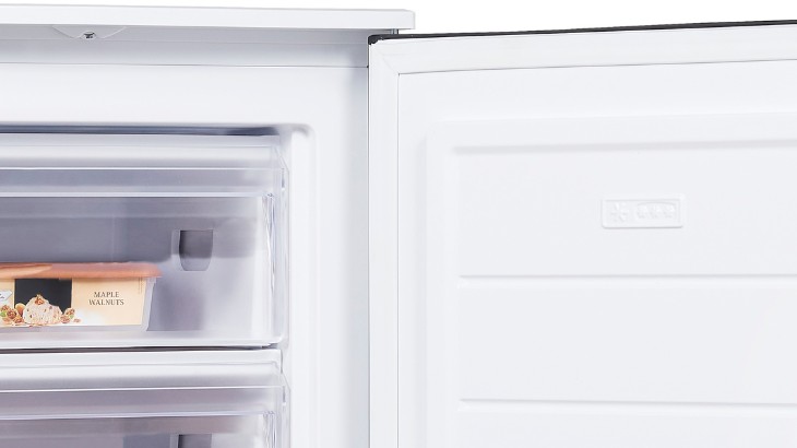 Eine Nahaufnahme eines offenen, weißen Kühlschranks mit einem Behälter im Gefrierfach.