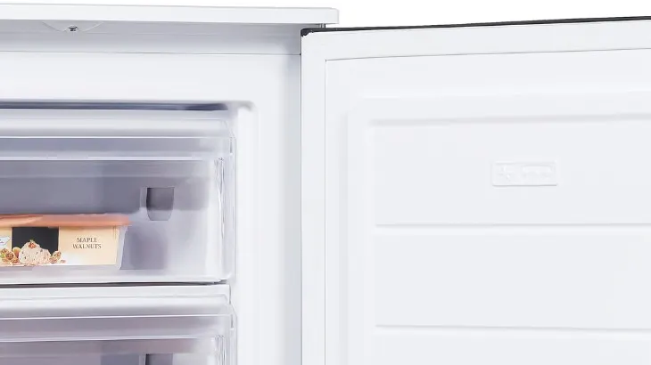 Eine Nahaufnahme eines offenen, weißen Kühlschranks mit einem Behälter im Gefrierfach.