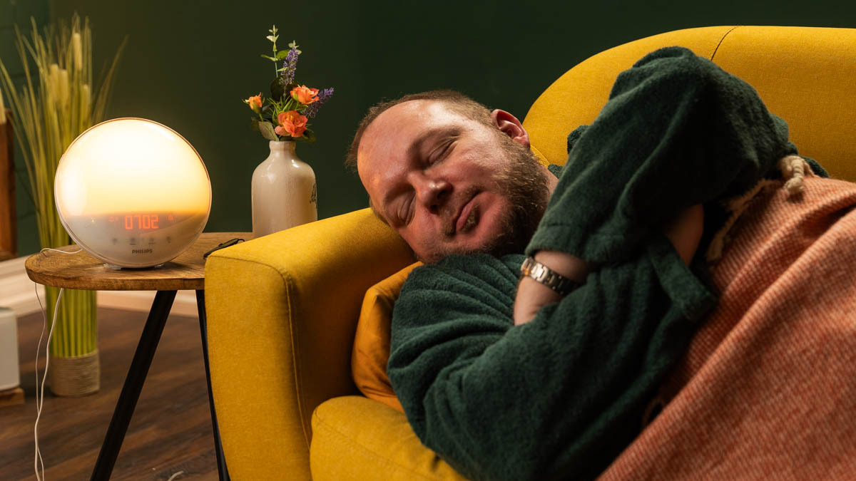 Andreas liegt auf einer Couch, daneben steht ein Philips-Lichtwecker auf einem Beistelltisch.