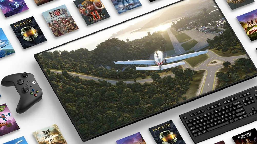 Ein Bildschirm zeigt ein Flugzeug über einer bewaldeten Landschaft, umgeben von einem Controller, einer Tastatur und Spielcovern.