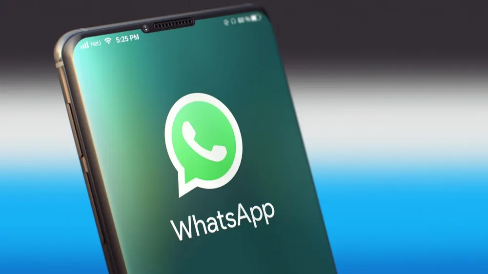 Nahaufnahme eines Smartphones mit grünem WhatsApp-Logo auf dem Display.