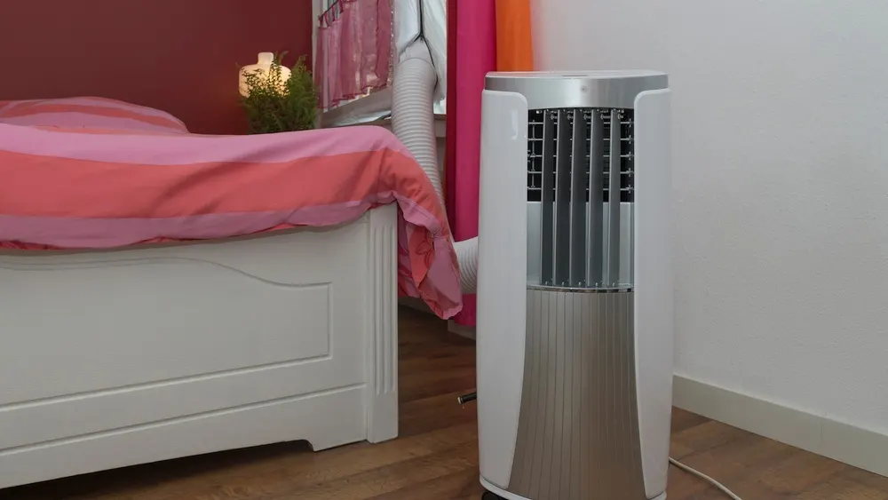 Eine Klimaanlage steht neben einem Bett.