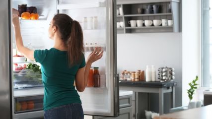 Frau nimmt Produkte aus dem Kühlschrank