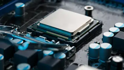 Nahaufnahme einer Computerplatine mit CPU, Kondensatoren und blauen Akzenten.