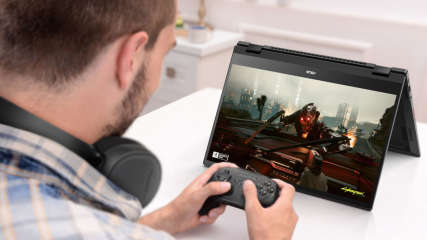 Ein Mann spielt mit Controller an einem Asus-Chromebook.