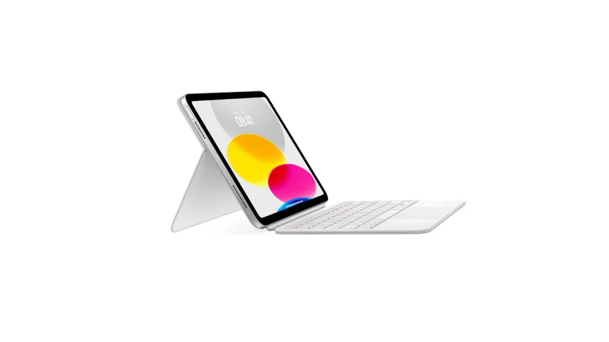Ein Tablet mit einem gelben, pinken und blauen Punkt auf dem Bildschirm steht auf einer weißen Hülle. Eine weiße Tastatur liegt daneben.