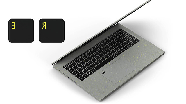 Silberner Laptop mit schwarzer Tastatur, teilweise geöffnet. Zwei schwarze Tasten mit gelben Buchstaben links.