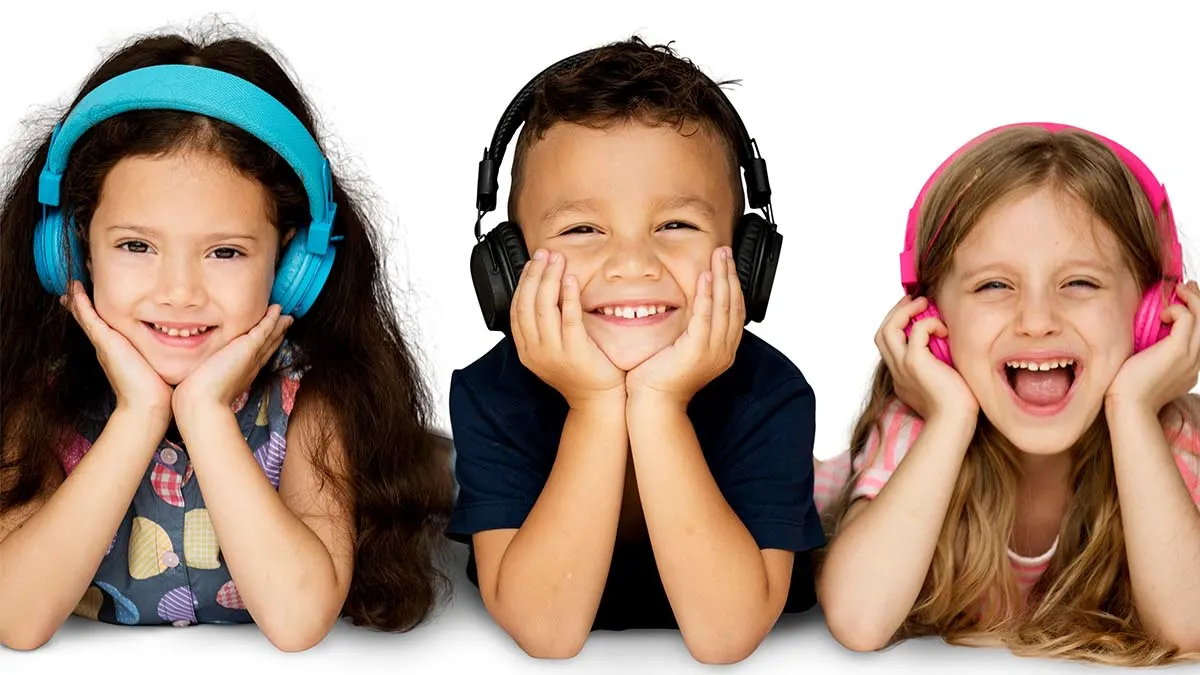Drei lachende Kinder stützen ihre Köpfe auf die Hände und tragen Kopfhörer.
