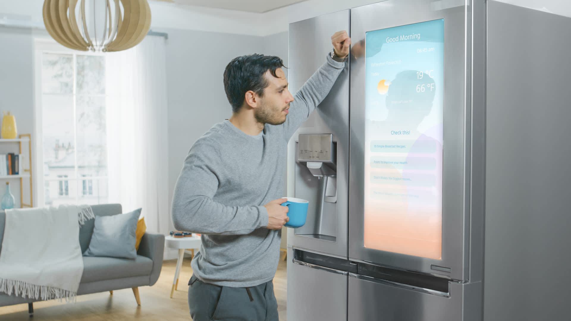 Ein Mann blickt auf den Touchscreen eines Kühlschranks.