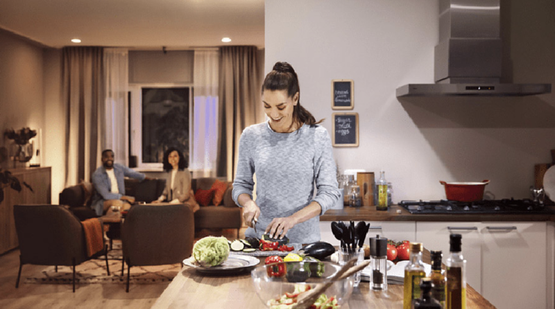Eine Frau steht in der Küche und schneidet Gemüse