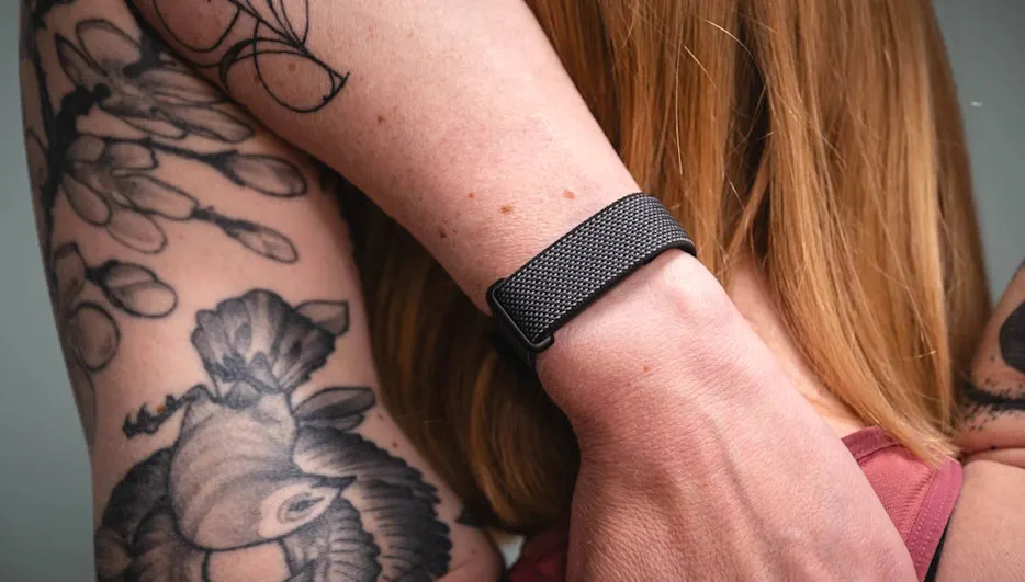 Franzi dehnt ihre Schulter und trägt dabei das Fitbit Air am linken Handgelenk.