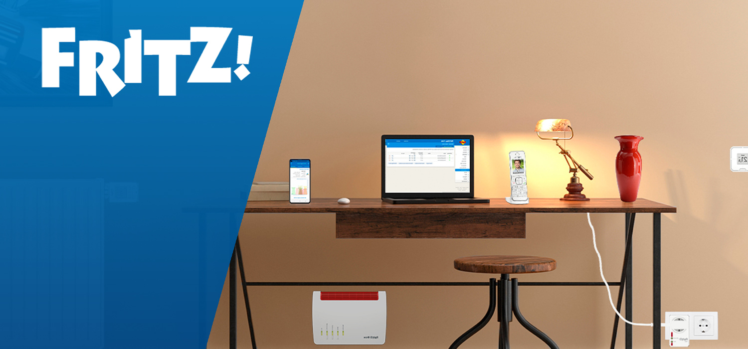 Modern eingerichteter Arbeitsplatz mit Laptop, Smartphone, Lampe und Vase auf einem Holztisch. Unter dem Tisch steht ein FRITZ!Box-Router. Links im Bild ist das blaue FRITZ!-Logo zu sehen.