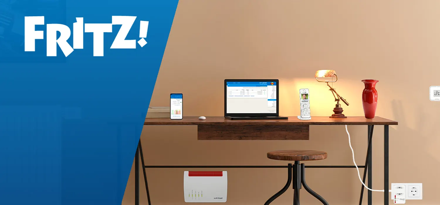 Modern eingerichteter Arbeitsplatz mit Laptop, Smartphone, Lampe und Vase auf einem Holztisch. Unter dem Tisch steht ein FRITZ!Box-Router. Links im Bild ist das blaue FRITZ!-Logo zu sehen.