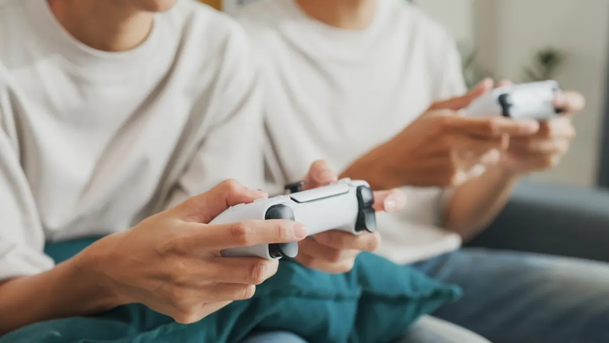 Zwei Personen bedienen Gaming-Controller.