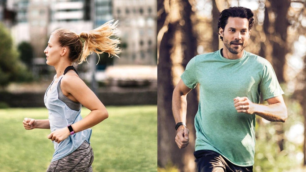Frau mit lilafarbener Fitbit Charge 4 und Mann mit schwarzer Fitbit Charge 3 joggen