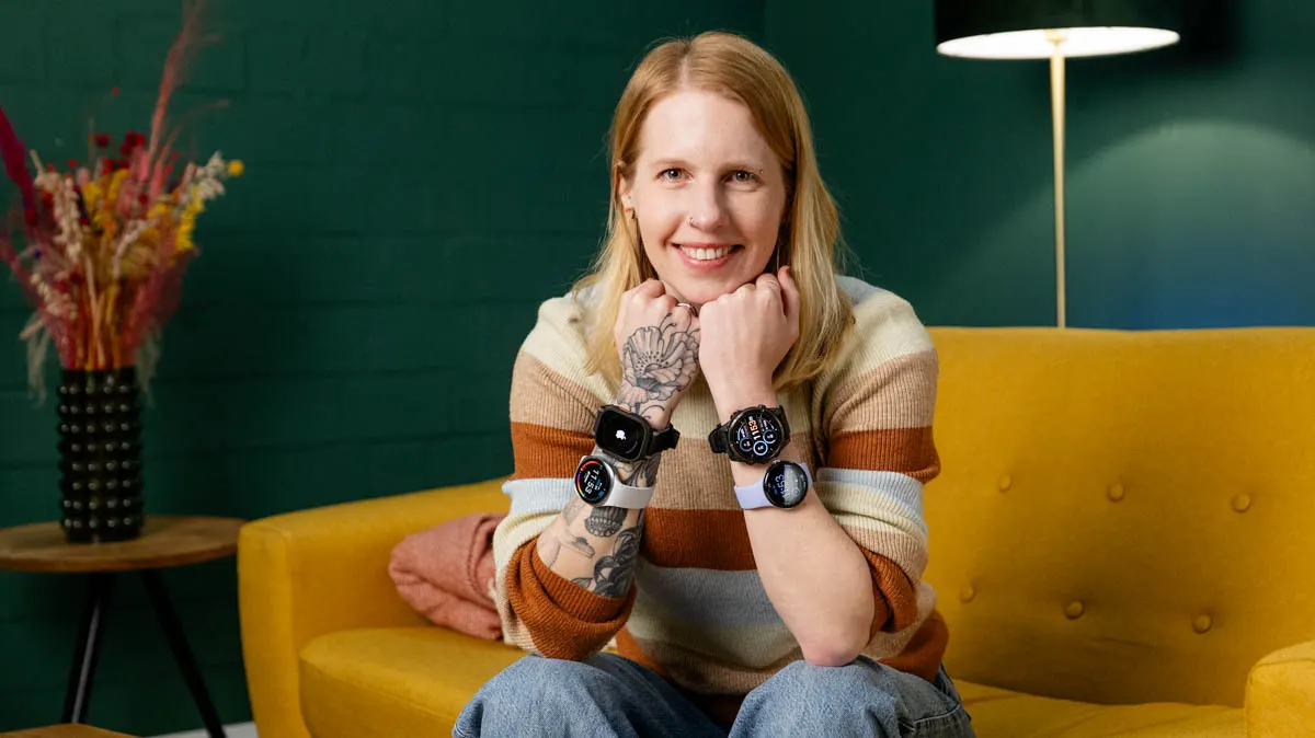 Franzi sitzt auf dem Sofa und trägt je zwei Smartwatches an jedem Arm.